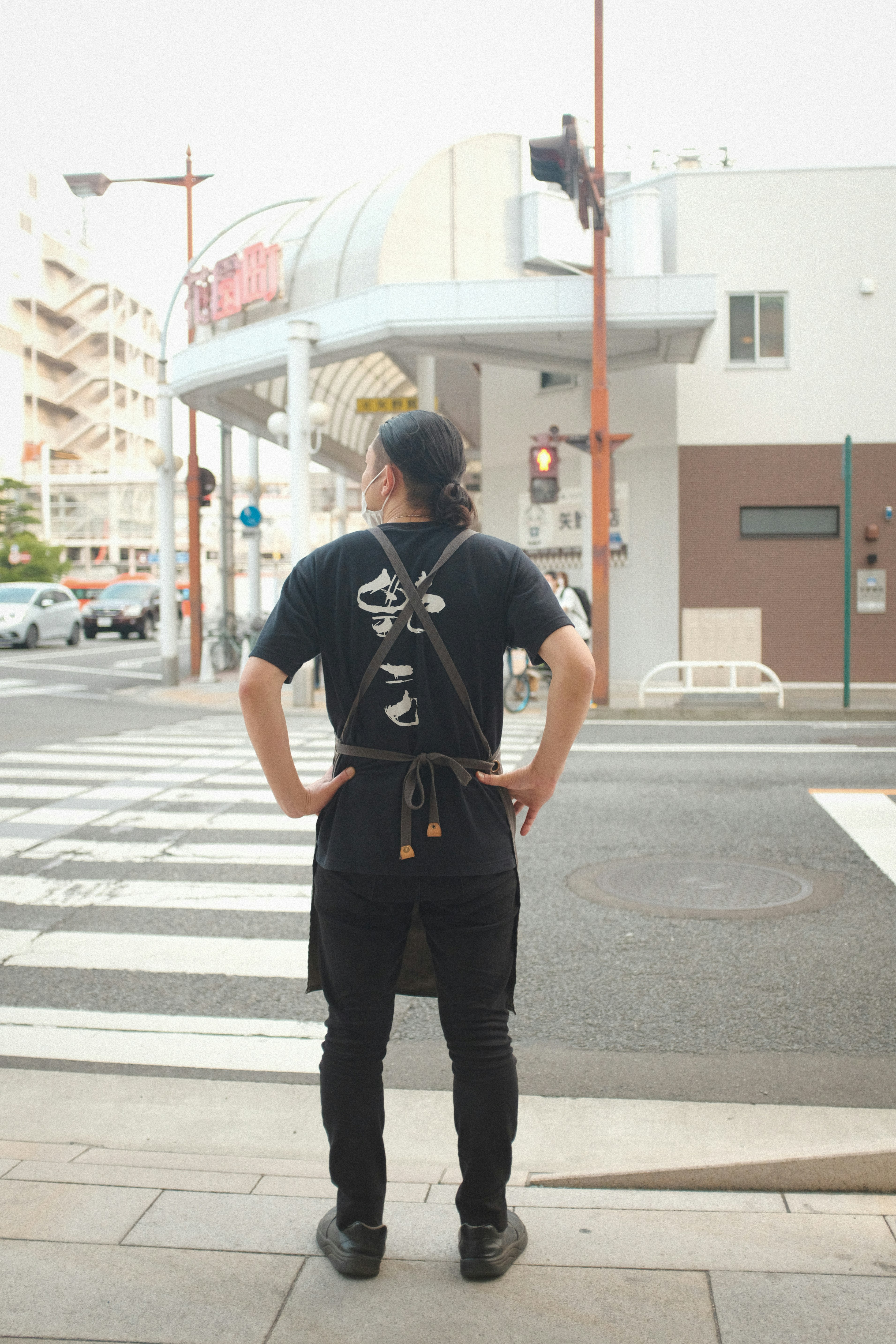 man in black t-shirt and black pants standing on pedestrian lane during daytime